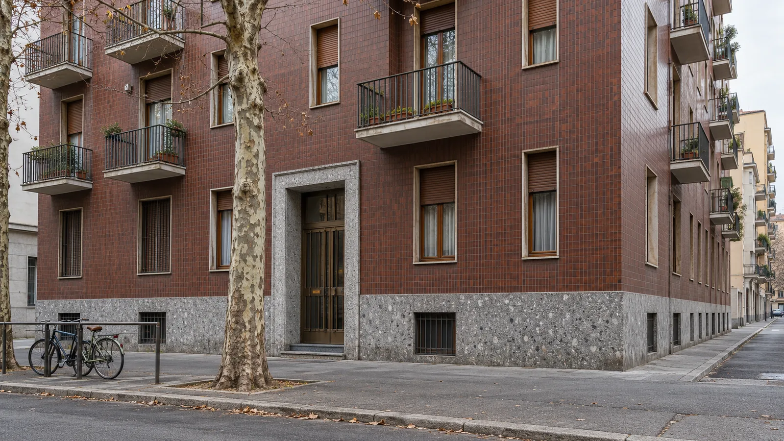 Palazzina milanese degli anni Cinquanta con facciata in klinker, basamento in ceppo e balconi con parapetti in ferro